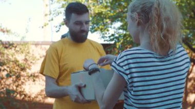 Postacı bir parsel genç bir kadın için sunar.