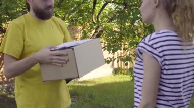 Postacı bir parsel genç bir kadın için sunar.