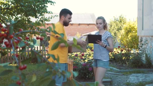 Brevbäraren levererar ett paket för en ung kvinna — Stockvideo