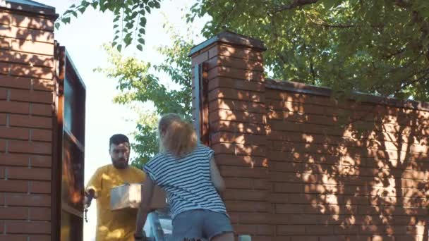Постмен доставляє посилку для молодої жінки — стокове відео