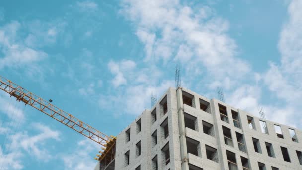 Guindastes de construção para construção em um fundo de céu azul com nuvens brancas — Vídeo de Stock