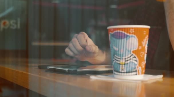 Man using tablet and drinking coffee in cafe window — Stock Video