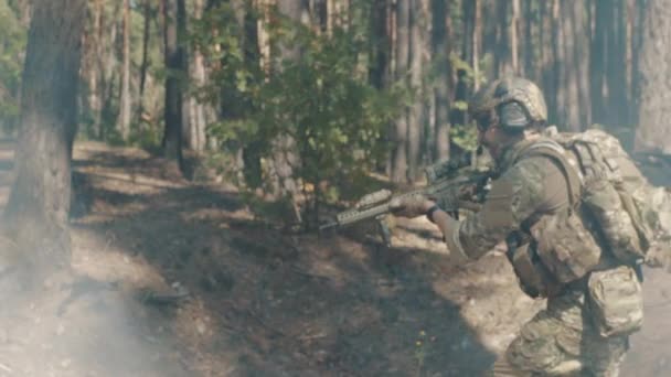 Tropas del ejército estadounidense con rifles toman posiciones de tiro en el bosque — Vídeos de Stock