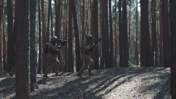 Soldados del Ejército de los Estados Unidos corren a atacar en un bosque humeante — Vídeo de stock