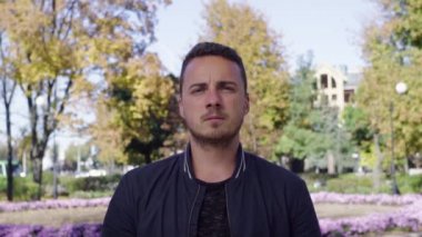 Çığlık atan adam parkta kapalı gözler kulaklarıyla kapsayan