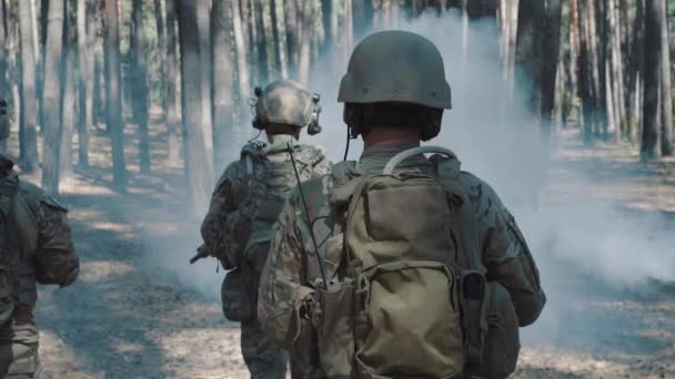 US Army soldiers patrol in a smoky forest — Stock Video