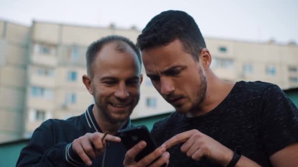 Deux hommes heureux émotionnellement après les nouvelles au téléphone — Video