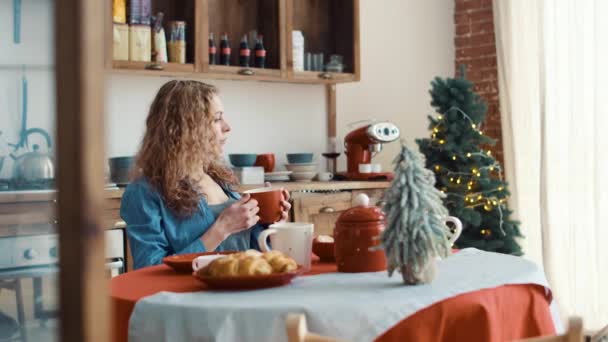 Menina bonita na cozinha com xícara de café pela manhã antes do Natal — Vídeo de Stock