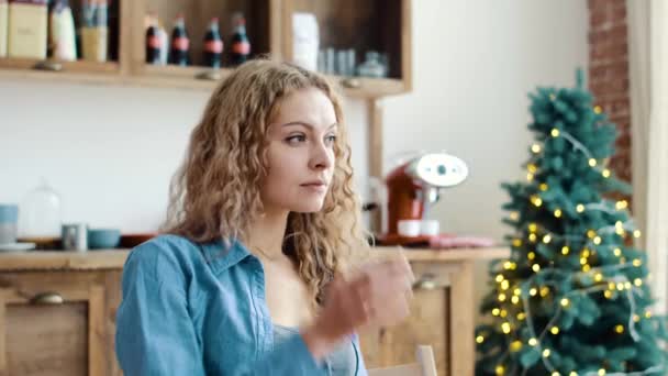 A lány mosolyogva, és néz a kamerába reggel a konyhában — Stock videók