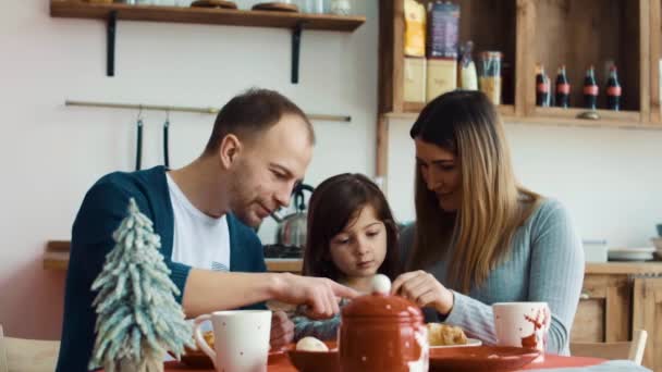 Молодая семья с дочерью на кухне — стоковое видео