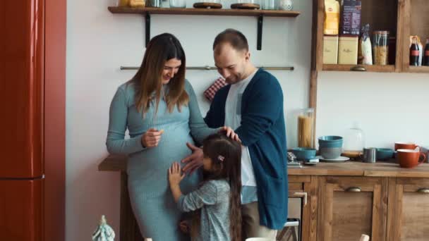 Вагітна жінка чоловік і дочка на кухні — стокове відео