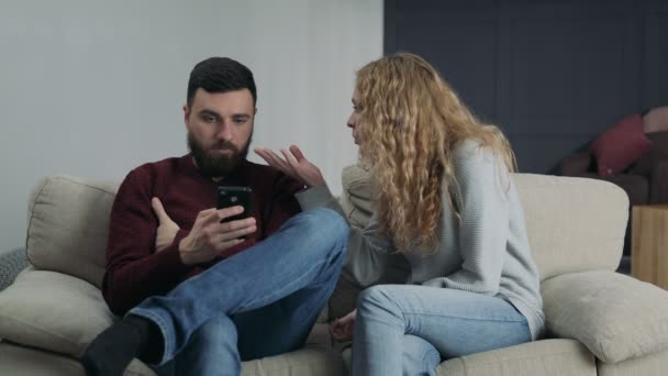 Dziewczyna krzyczy na swojego chłopaka, który jest wpisanie w telefonie — Wideo stockowe