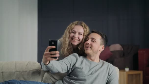 Feliz joven pareja tomando foto selfie junto con un teléfono móvil — Vídeo de stock