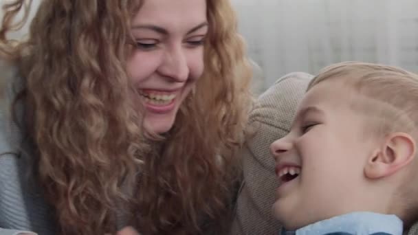 Mamá cosquillas hijo en el sofá — Vídeo de stock