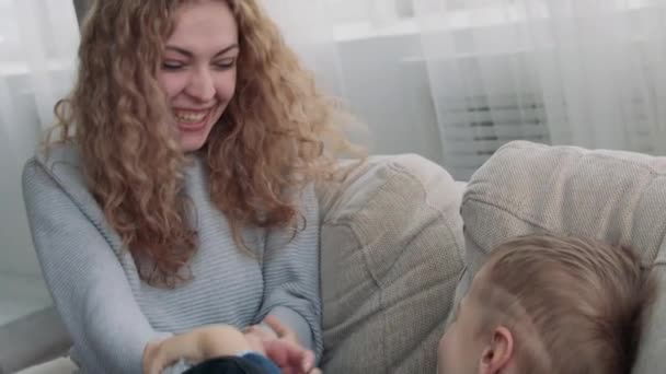 Máma lechtá syna na gauči — Stock video