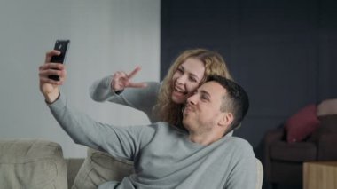 Çift selfie akıllı telefon kamera, possing ve evde gülümseyen yapma
