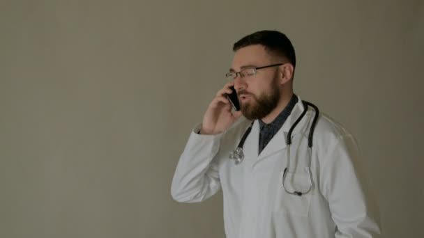 Läkaren går med en smartphone i en sjukhuskorridor. — Stockvideo