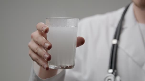 Szklankę wody i aspiryna tabletki w ręce lekarzy — Wideo stockowe