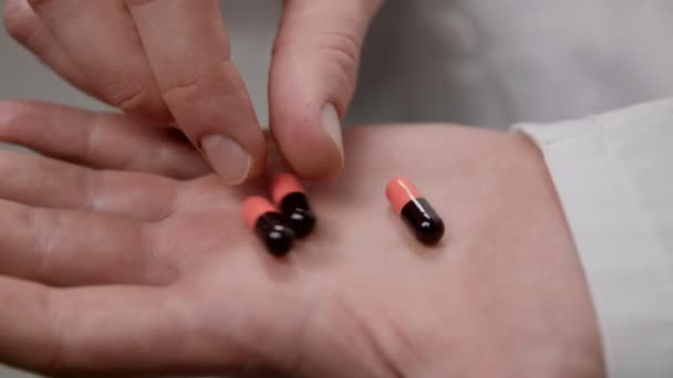 Доктор держит в руке несколько таблеток. . — стоковое видео