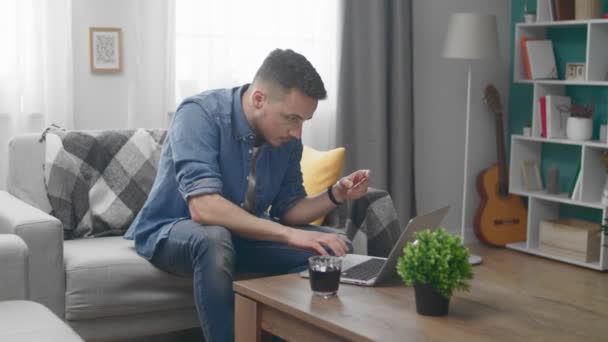 Man at Home He Holds Credit Card and Types Its Number into His Laptop — Stock Video