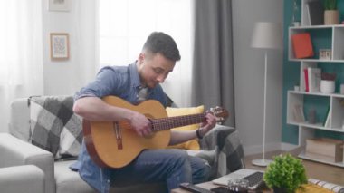 Yakışıklı adam akustik gitar çalmayı öğreniyor