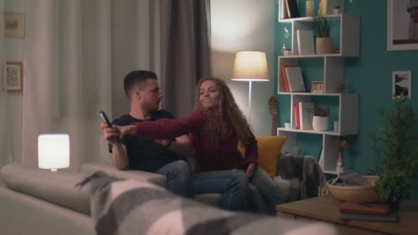 Zoom in of man and woman fighting for remote tv in living room at evening — Stock Video