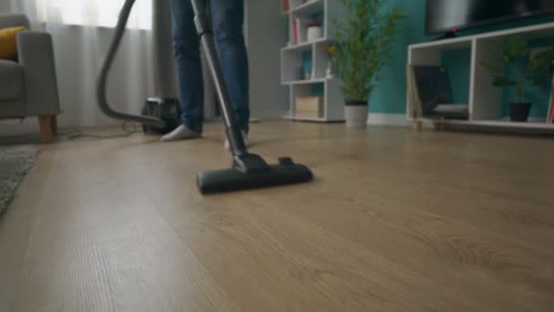 Zbliżenie Man sprzątanie przytulne mieszkanie z odkurzacza — Wideo stockowe