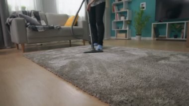 Onu rahat oturma odasında halı vakumlama genç güzel kız el çekim