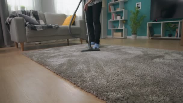 彼女の居心地の良いリビングルームでカーペットを掃除する若い美しい女の子のハンドヘルドショット — ストック動画