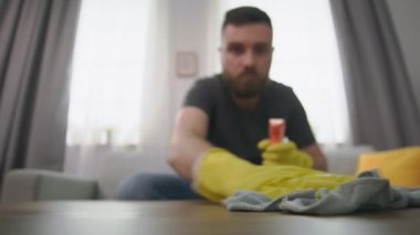 Geniş açı kahve masasındaki tozu siliyor.