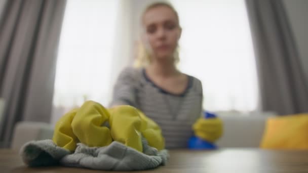 Close-up shot van aantrekkelijke vrouw veegt een salontafel met een rag — Stockvideo