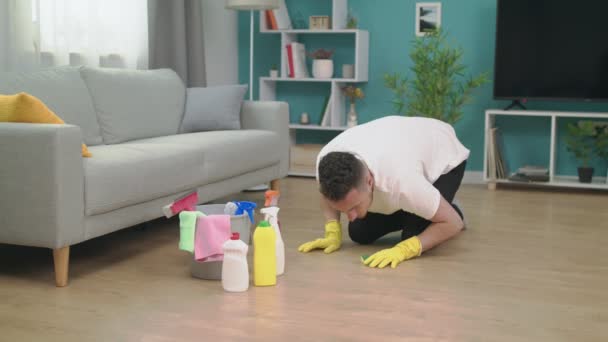 Junger Mann beim Aufräumen nach dem Umzug in eine neue Wohnung. Neues Konzept der Hausreinigung — Stockvideo