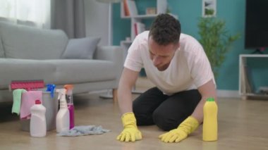 Man Tilting temizlik ten sonra oturma odasında yerde oturan yorgun hissediyorum