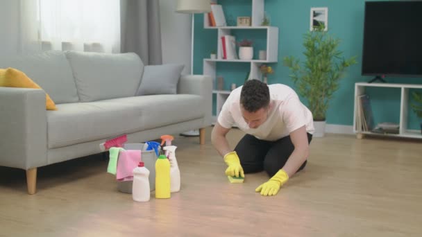 Jeune homme rangeant après avoir déménagé dans un nouvel appartement. Nouveau concept de nettoyage de maison — Video