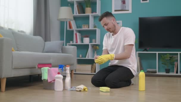 Vermoeide man neemt zijn handschoenen af na het schoonmaken van de vloer — Stockvideo