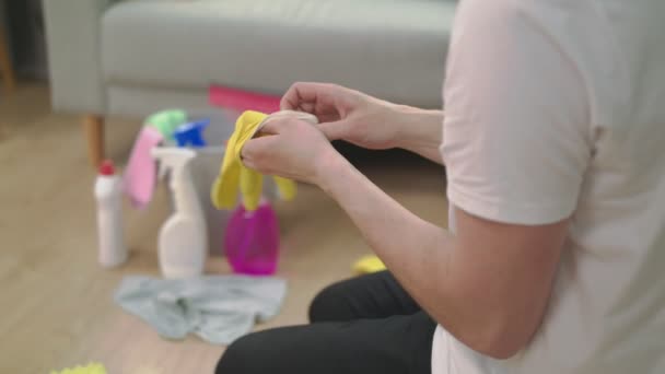 Портативний знімок людини одягає рукавички перед прибиранням своєї вітальні — стокове відео