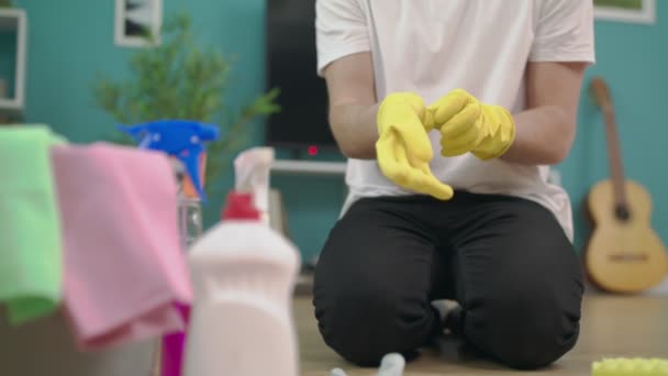 Gros plan de l'homme met des gants avant de nettoyer son salon — Video