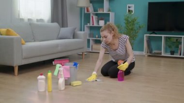 Yorgun kadın dairesini temizledikten sonra alnını siliyor