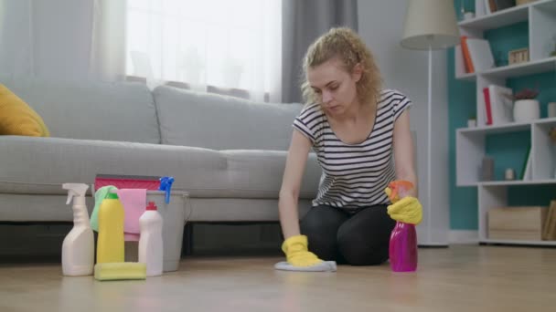 Plan moyen de la femme en gants jaunes avec chiffon nettoyage plancher dans le salon — Video