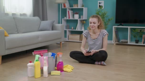Wanita muda ceria selesai membersihkan ruang tamu — Stok Video