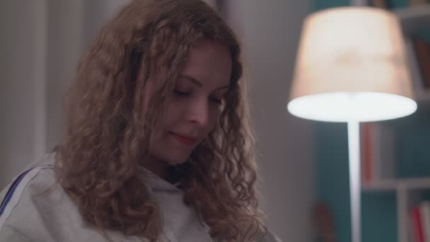 Akşam Güzel Genç Kadın Onu Rahat Oturma Odasında Bir Kanepede Rahatlatır — Stok video