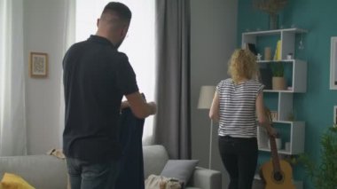 Bir partiden sonra oturma odasını temizleyen çift