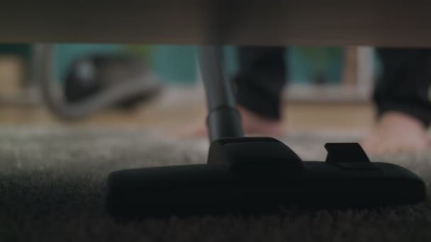 Close-up shot of cleaning a floor under a bed using vacuum cleaner — Stock Video