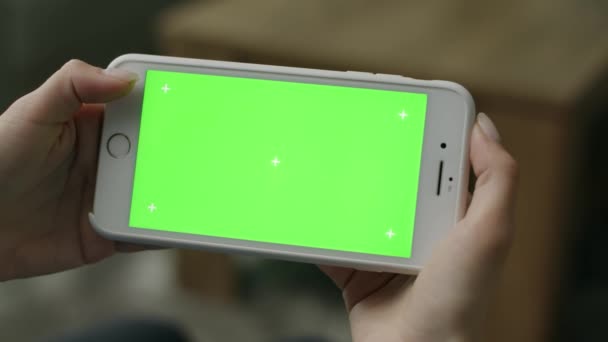 Женщина дома сидит на диване, используя смартфон Green Mock-up Screen — стоковое видео