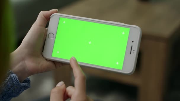 Vrouw thuis zitten op een bank met behulp van met Green Mock-up Screen Smartphone — Stockvideo