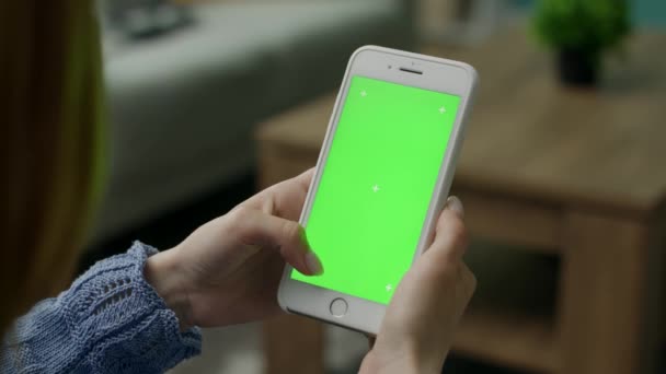 Женщина дома сидит на диване, используя смартфон Green Mock-up Screen — стоковое видео