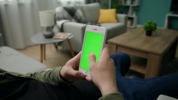 Yeşil Mock-up Ekran ile Smartphone kullanarak Bir Kanepede Evde Man Sitng — Stok video