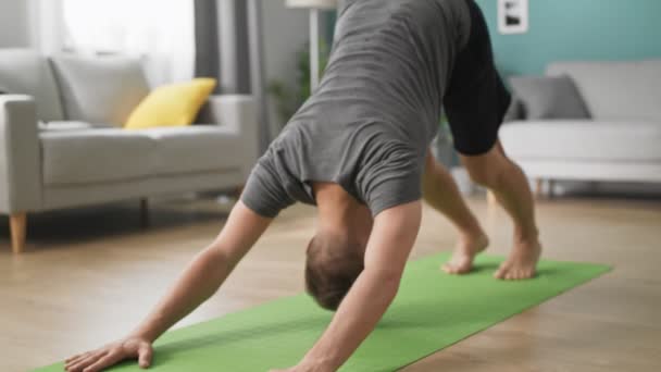 Jovem fazendo ioga de manhã em sua sala de estar — Vídeo de Stock
