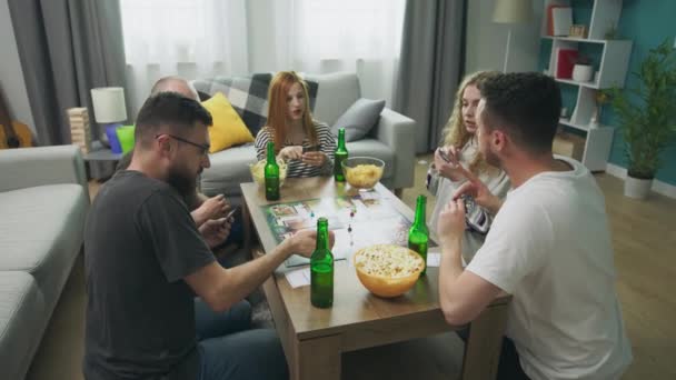Nel soggiorno gli amici geek giocano un gioco da tavolo strategico — Video Stock
