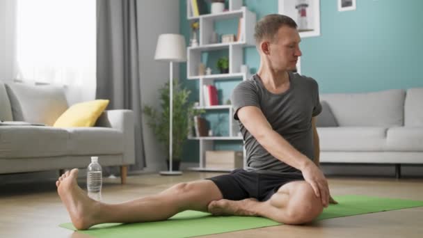 Человек во время индивидуальных тренировок на дому расслабляющие мышцы и забота о здоровье — стоковое видео
